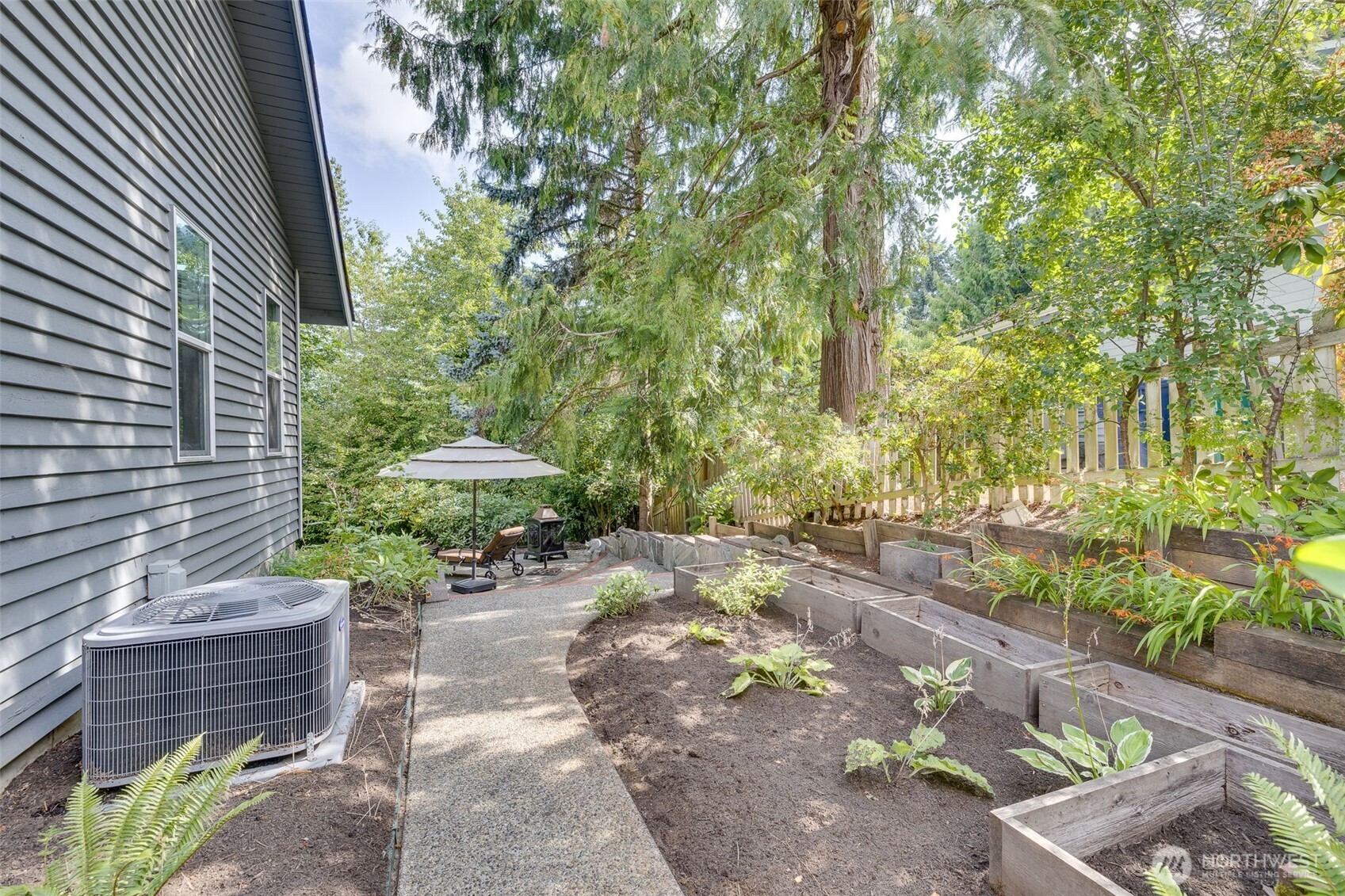 4310 209th Avenue Northeast Sammamish, WA 98074 - Photo 32 of 39 a backyard of a house with table and chairs under an umbrella
