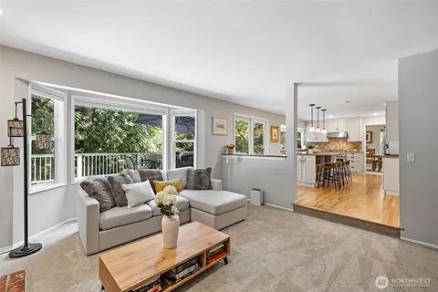 a view of a dining room and livingroom with furniture wooden floor a chandelier