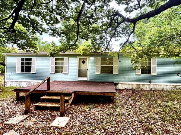 a view of a wooden chairs and bench in the backyard of a house