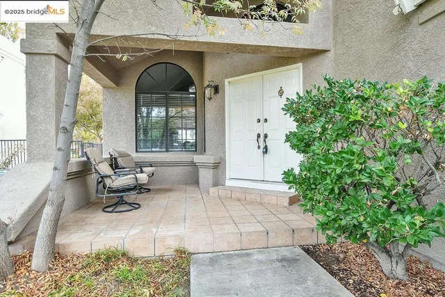 a view of an entryway with wooden floor leading to a furnished livingroom and windows