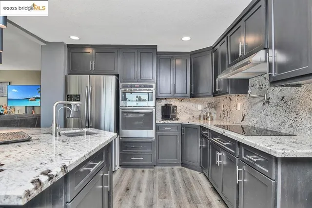 a kitchen with kitchen island granite countertop a sink stove and refrigerator