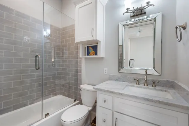 a bathroom with a granite countertop sink toilet and shower