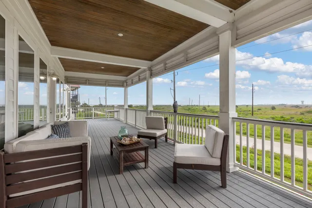 a balcony with wooden floor table and chairs