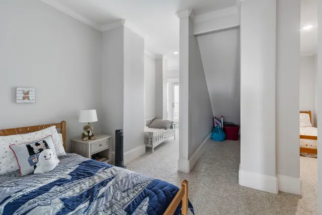 a bedroom with a bed and large windows