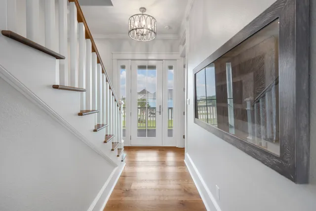 a view of a hallway with wooden floor and staircase