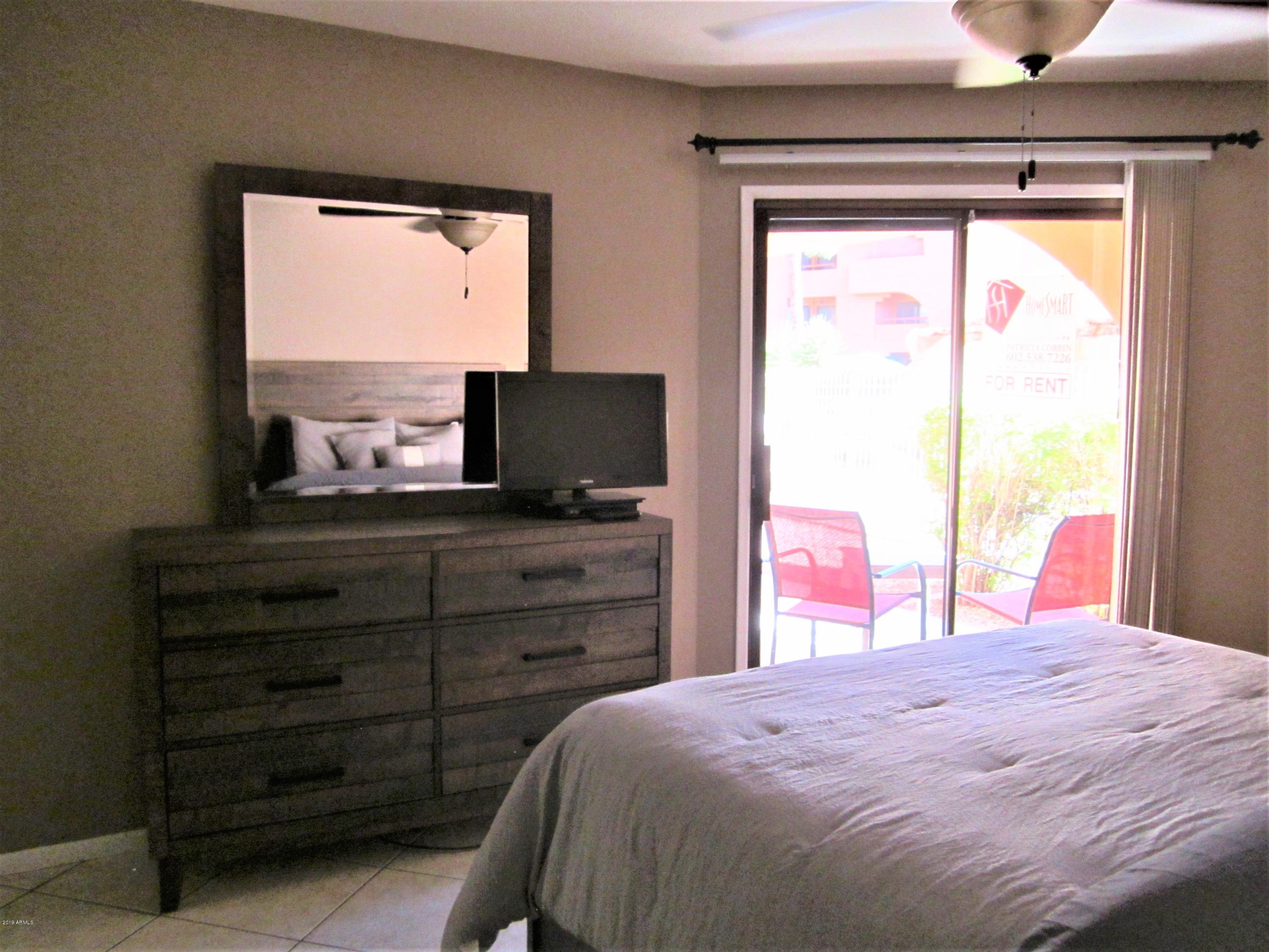 4303 East Cactus Road, Unit 116 Phoenix, AZ 85032 - Photo 14 of 35 a bedroom with a bed and a flat screen tv