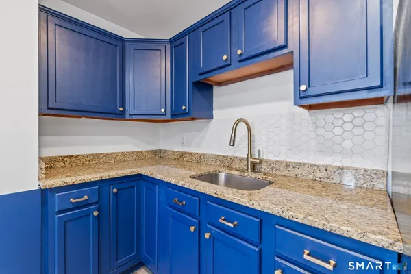 a kitchen with granite countertop wooden cabinets and a sink