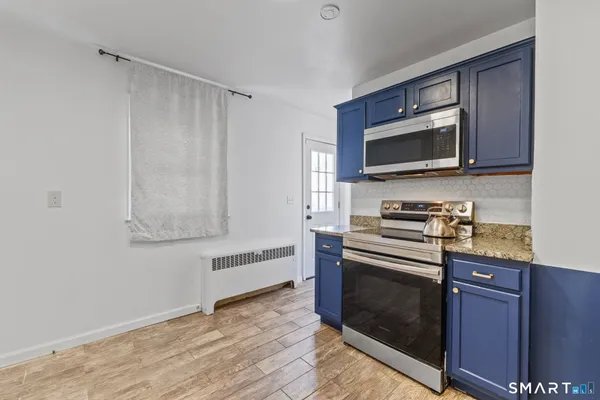 a kitchen with granite countertop a stove and a microwave