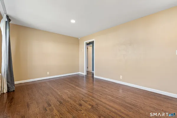an empty room with wooden floor and closet