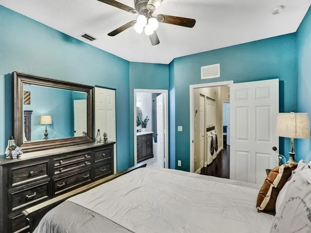 a bedroom with a bed and a large mirror on the dresser