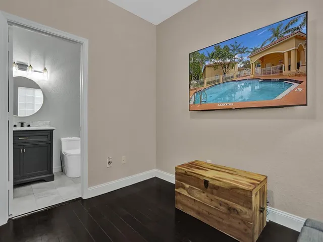 a room with a wooden floor and a potted plant