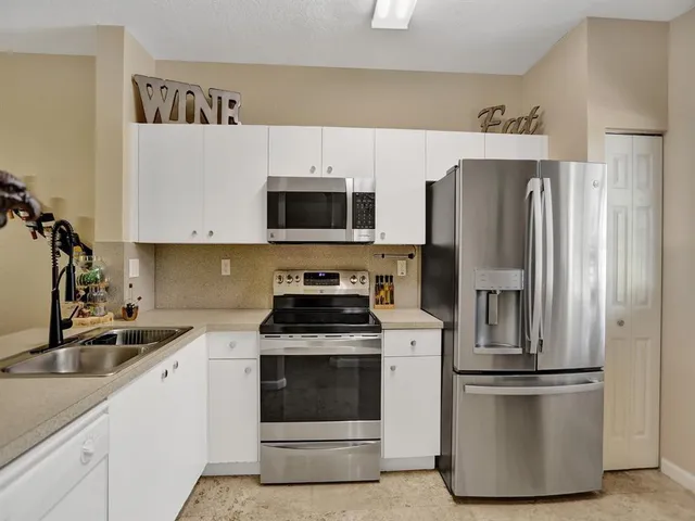 a kitchen with stainless steel appliances a refrigerator stove and microwave