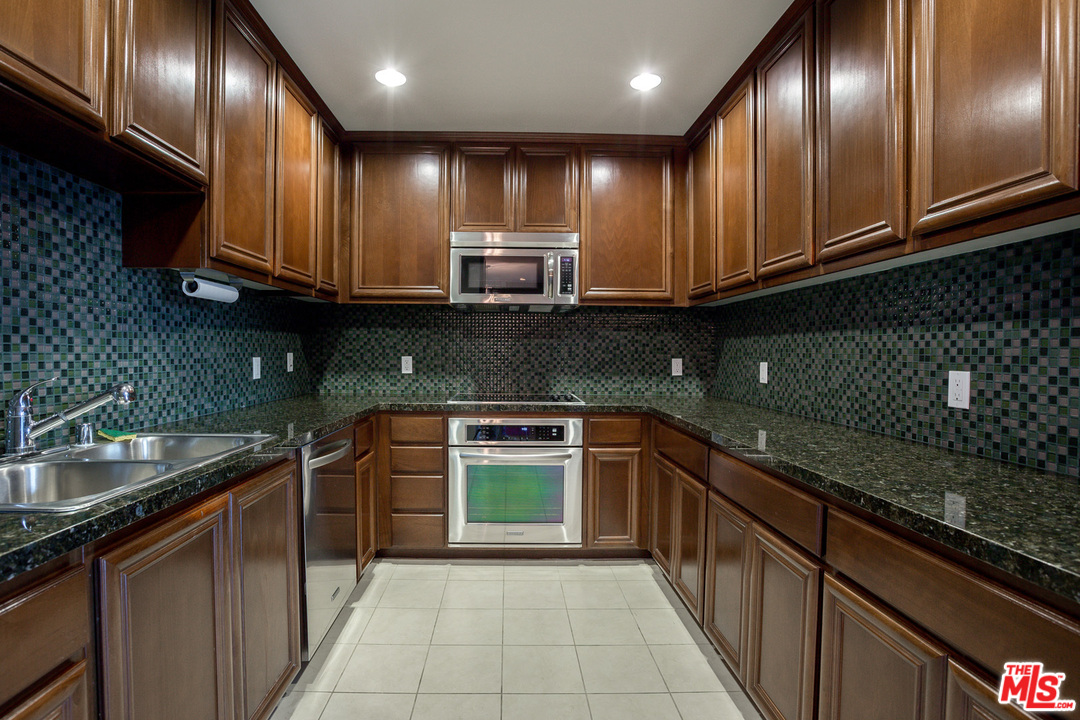 a kitchen with granite countertop stainless steel appliances and sink
