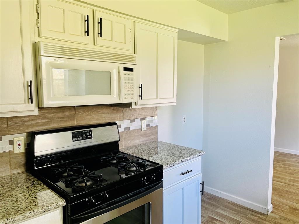 17002 Dew Drop Lane Houston, TX 77095 - Photo 6 of 14 a kitchen with stainless steel appliances granite countertop a stove and a microwave