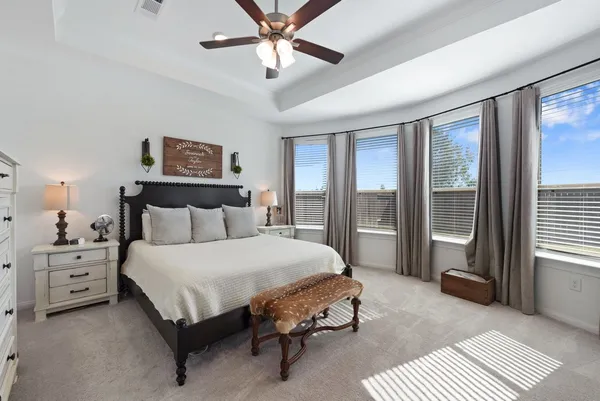 a spacious bedroom with a bed a window and a chandelier