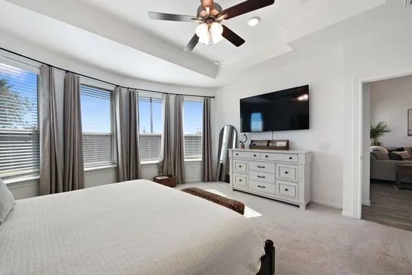 a bedroom with a bed and a flat tv screen on dresser