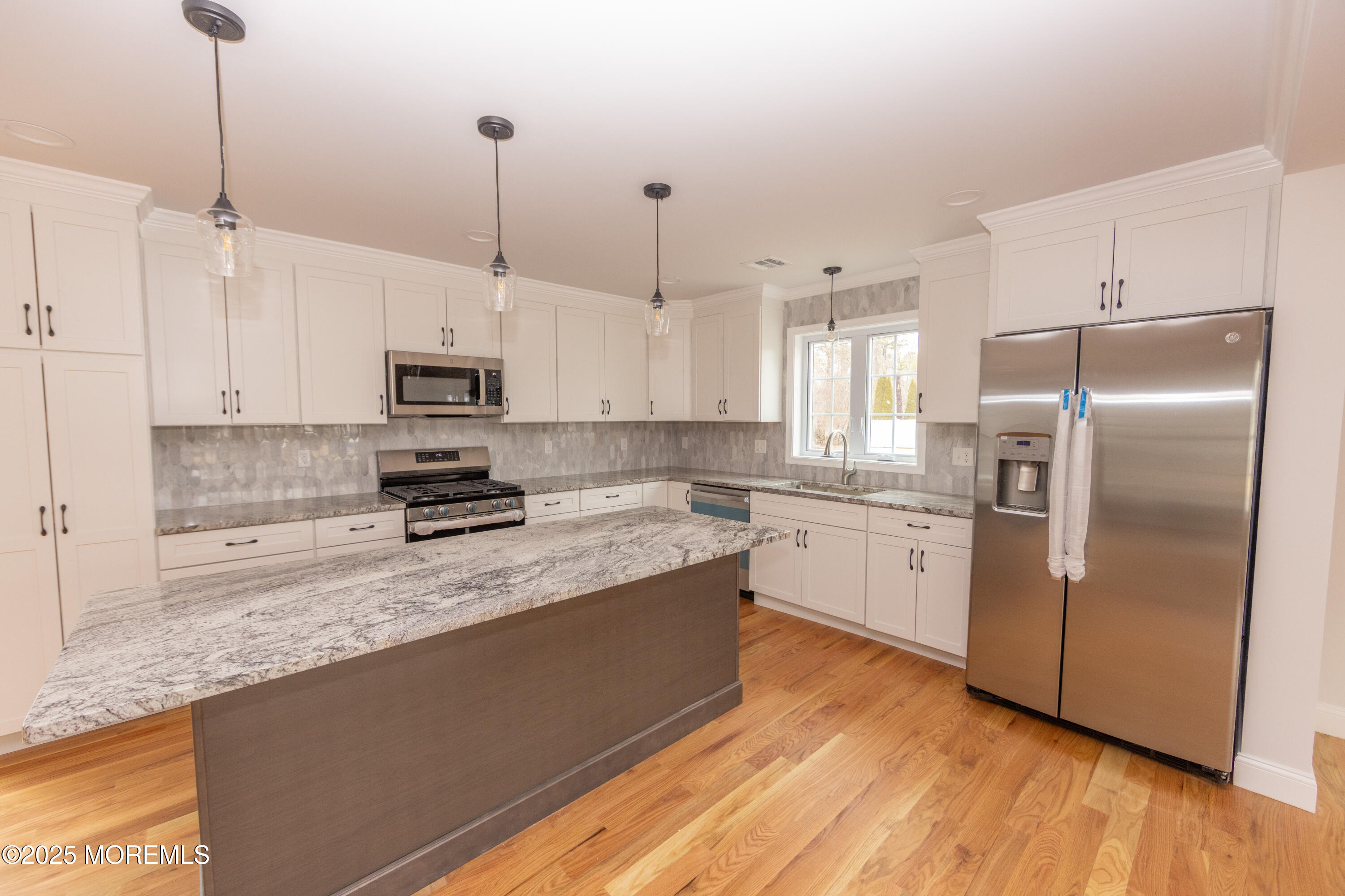1517 Whitcomb Road Forked River, NJ 08731 - Photo 4 of 18 a kitchen with stainless steel appliances granite countertop a refrigerator a sink a stove and white cabinets