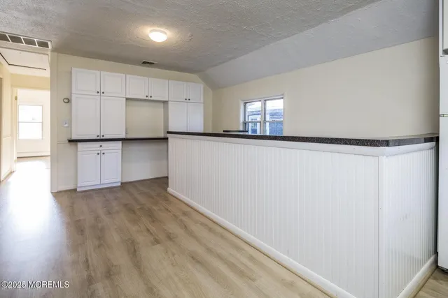 a large kitchen with a wooden floor and stainless steel appliances