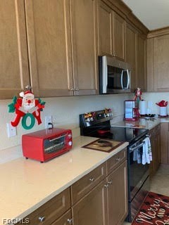 3740 Pebblebrook Ridge Court, Unit 102 Fort Myers, FL 33905 - Photo 7 of 46 a kitchen with stainless steel appliances a microwave a stove and cabinets