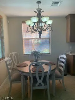 a view of a dining room with furniture and chandelier