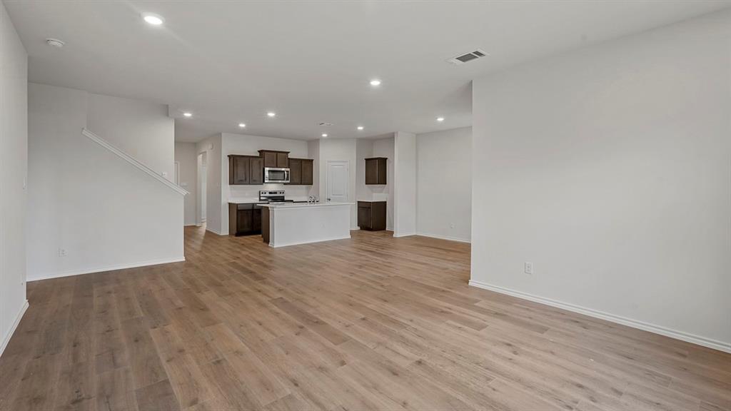 1627 Mantle Road Crandall, TX 75114 - Photo 9 of 40 Spacious interior with wood-finish flooring, recessed lighting, and a kitchen featuring dark wood cabinetry, a center island, and stainless steel appliances