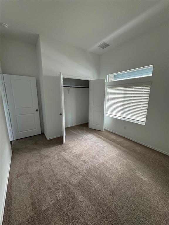 216 Jeffers Kyle, TX 78640 - Photo 8 of 19 Carpeted interior room with a double-door closet, white walls, and a large window featuring horizontal blinds
