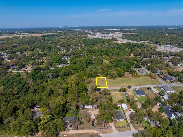 an aerial view of residential houses with outdoor space and trees