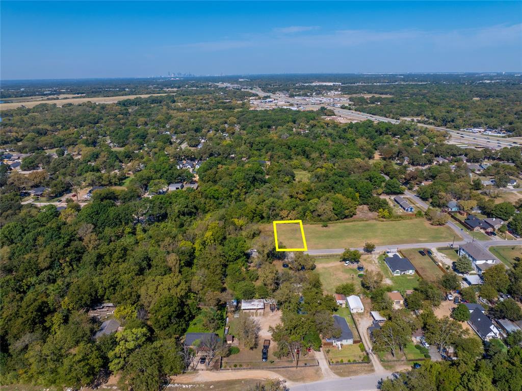 an aerial view of residential houses with outdoor space and trees