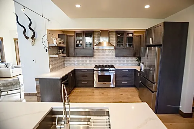 a kitchen with stainless steel appliances granite countertop a refrigerator and a stove
