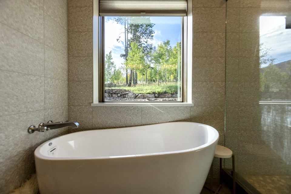 230 Game Trail Road Silverthorne, CO 80498 - Photo 20 of 46 a white bath tub sitting in a bathroom next to a window
