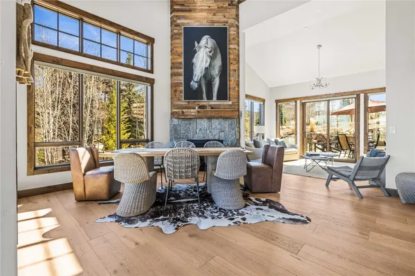 a living room with furniture a large window and wooden floor