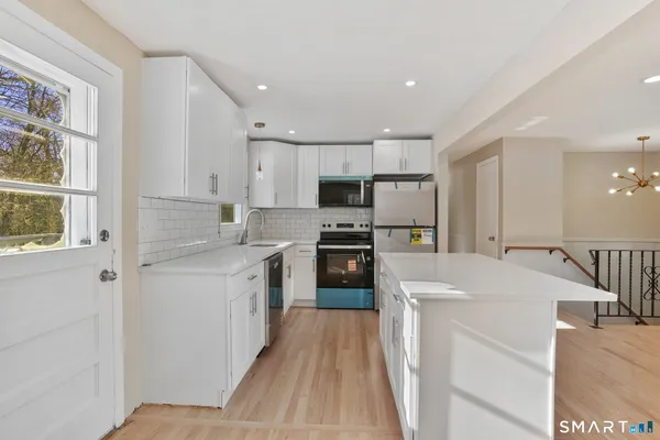 a kitchen with a sink a counter top space stainless steel appliances and a window