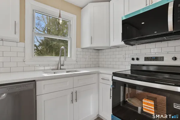 a kitchen with stainless steel appliances a stove sink and microwave