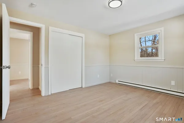 an empty room with a bench and mirror