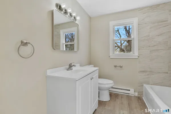 a bathroom with a toilet a sink and mirror