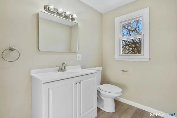 a bathroom with a toilet a sink and mirror
