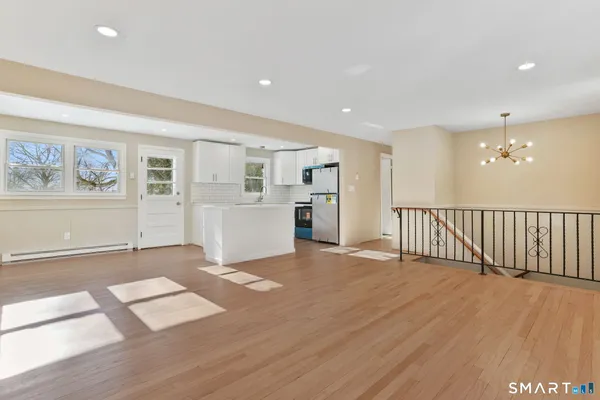 a view of a big room with wooden floor and windows