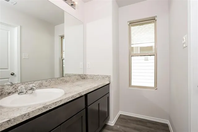 a bathroom with a granite countertop sink a mirror and a window
