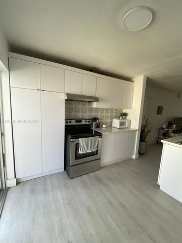 a kitchen with stainless steel appliances a stove top oven a sink and a refrigerator