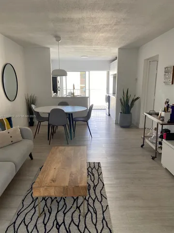 a living room with furniture wooden floor and dining table