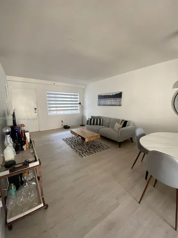 a living room with furniture a air conditioner vent and a window