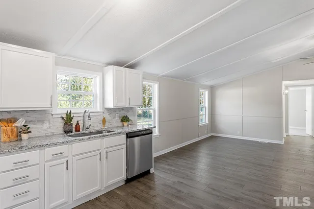 a kitchen with a sink wooden floor and window