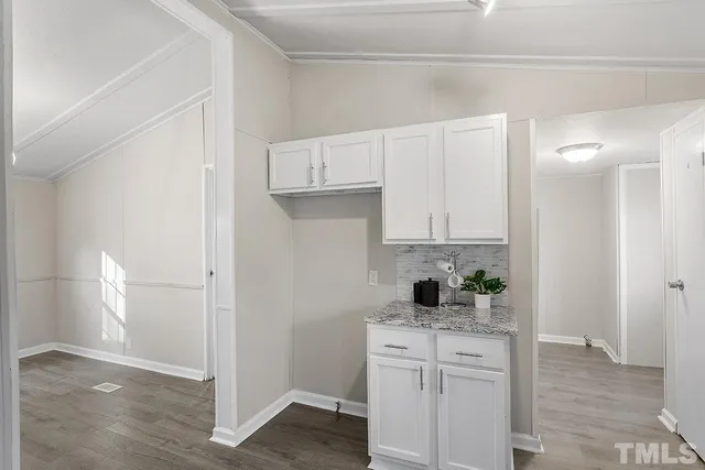 a kitchen with white cabinets and black appliances