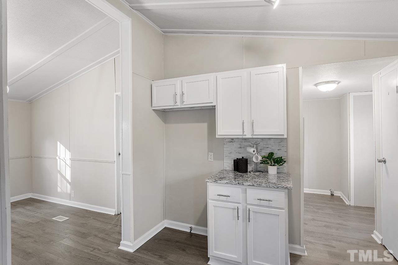 313 Smith Road Smithfield, NC 27577 - Photo 14 of 36 a kitchen with white cabinets and black appliances
