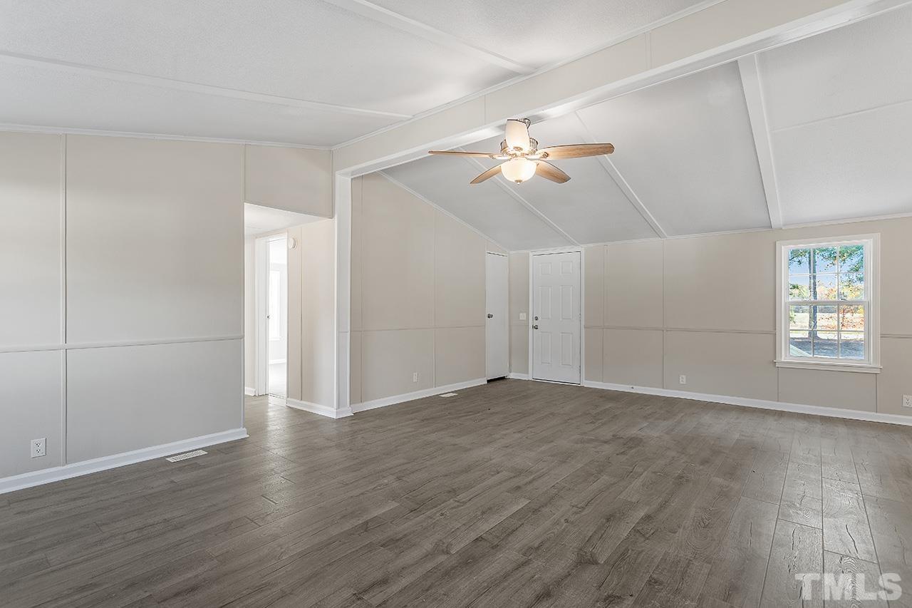 313 Smith Road Smithfield, NC 27577 - Photo 19 of 36 an empty room with wooden floor and ceiling fan