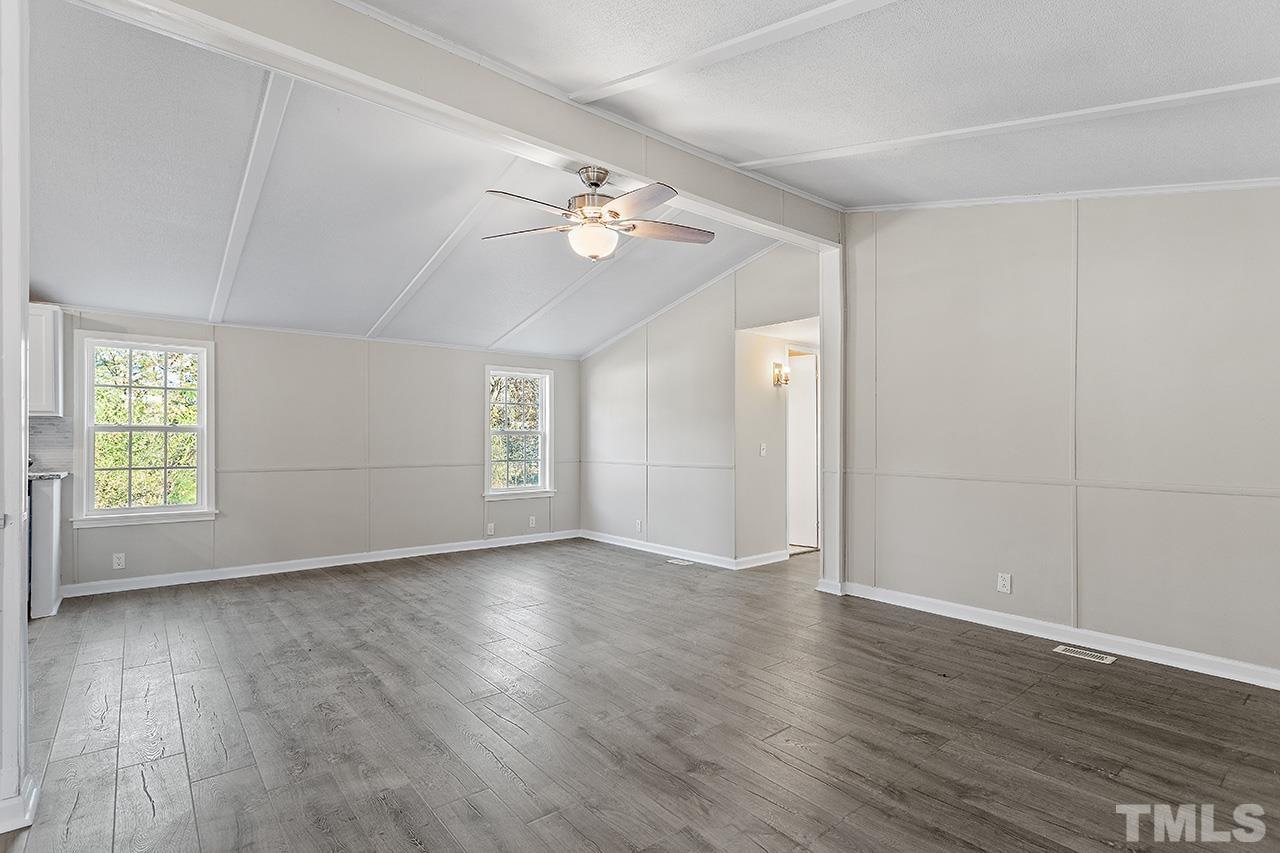 313 Smith Road Smithfield, NC 27577 - Photo 20 of 36 an empty room with wooden floor chandelier fan and windows