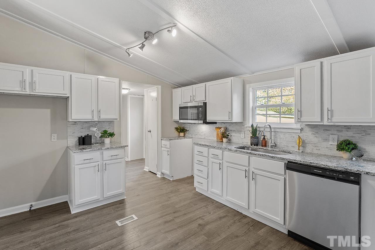 313 Smith Road Smithfield, NC 27577 - Photo 2 of 36 a kitchen with white cabinets and white appliances