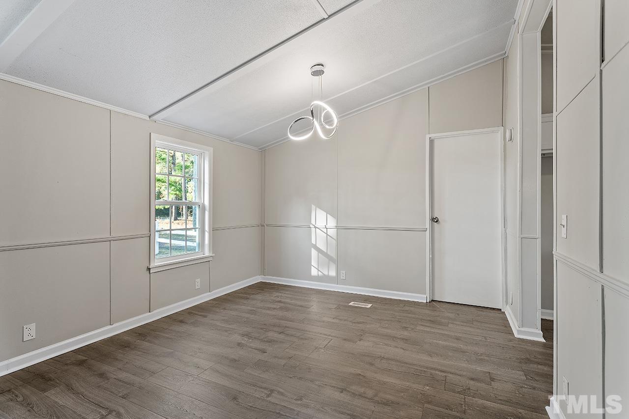 313 Smith Road Smithfield, NC 27577 - Photo 22 of 36 an empty room with wooden floor cabinet and windows