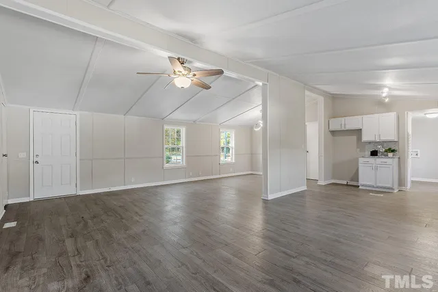a view of empty room with wooden floor and ceiling fan