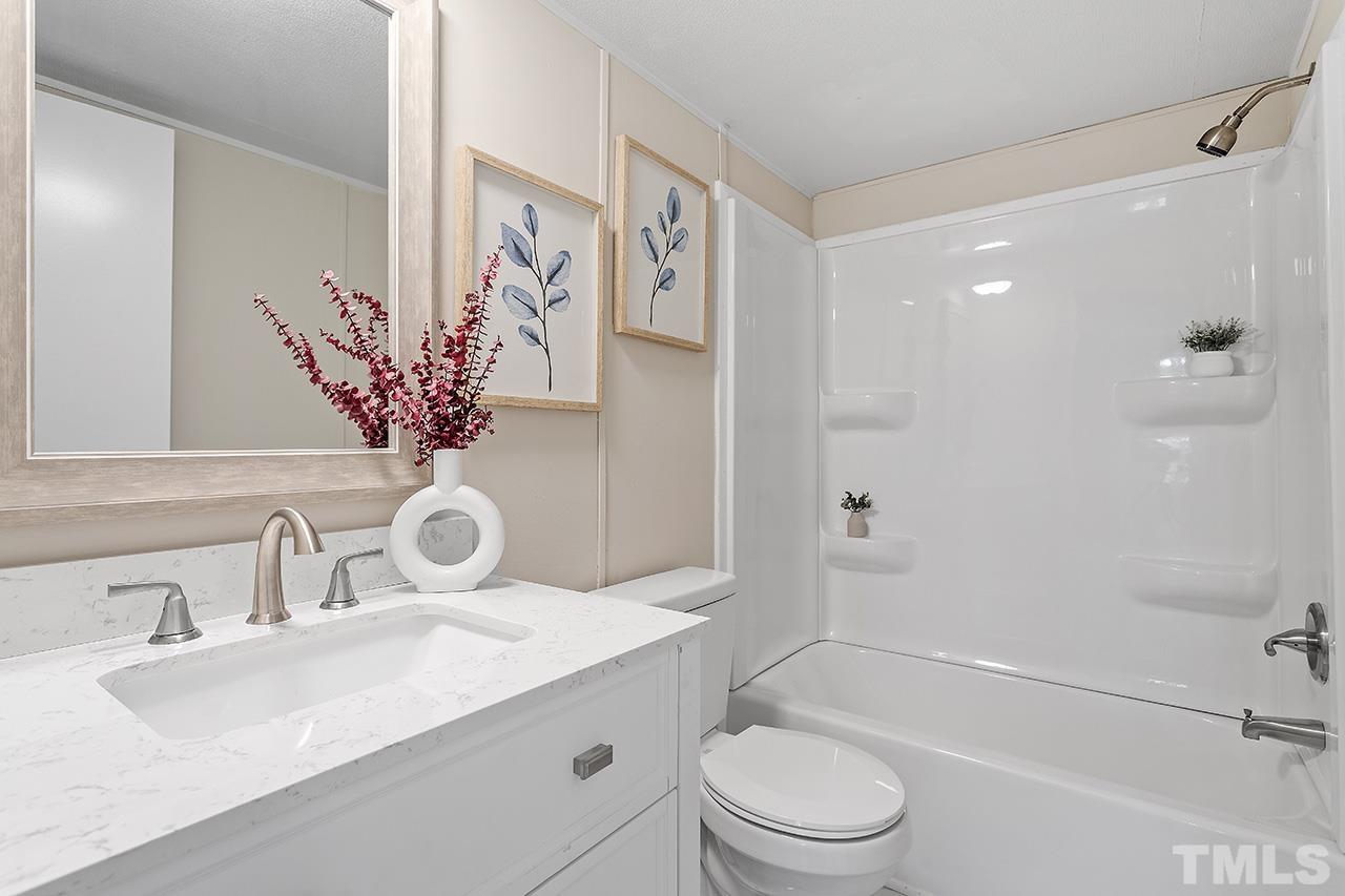 313 Smith Road Smithfield, NC 27577 - Photo 28 of 36 a bathroom with a granite countertop sink toilet and shower